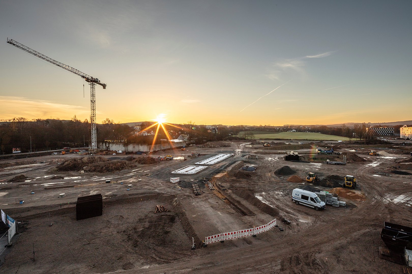 Neubaugebiet in Entwicklung im Projekt joseph – attraktive Immobilienlage Großbaustelle bei Sonnenuntergang mit Kran und Baustellenfahrzeugen