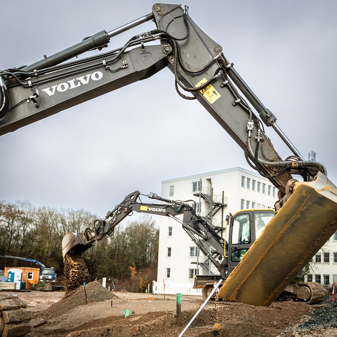 Neubauprojekt joseph in Vorbereitung – Wohnimmobilien in Entwicklung Baustellenarbeiten mit Baggern im Neubauprojekt joseph vor einem Wohngebäude